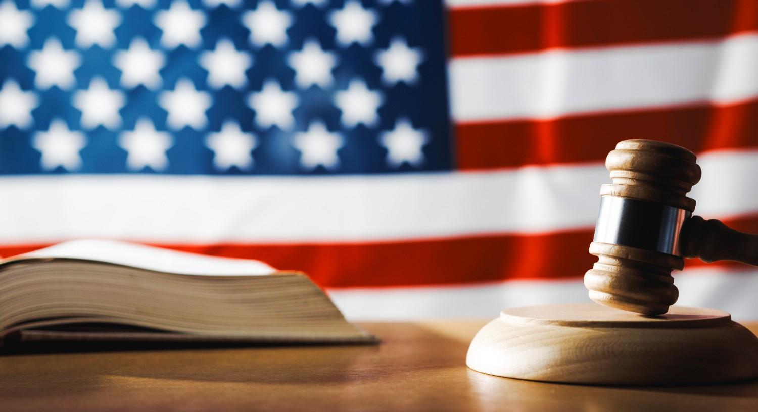 Judge gavel and law book before U.S. flag symbolizing federal vs state immigration law legal conflicts