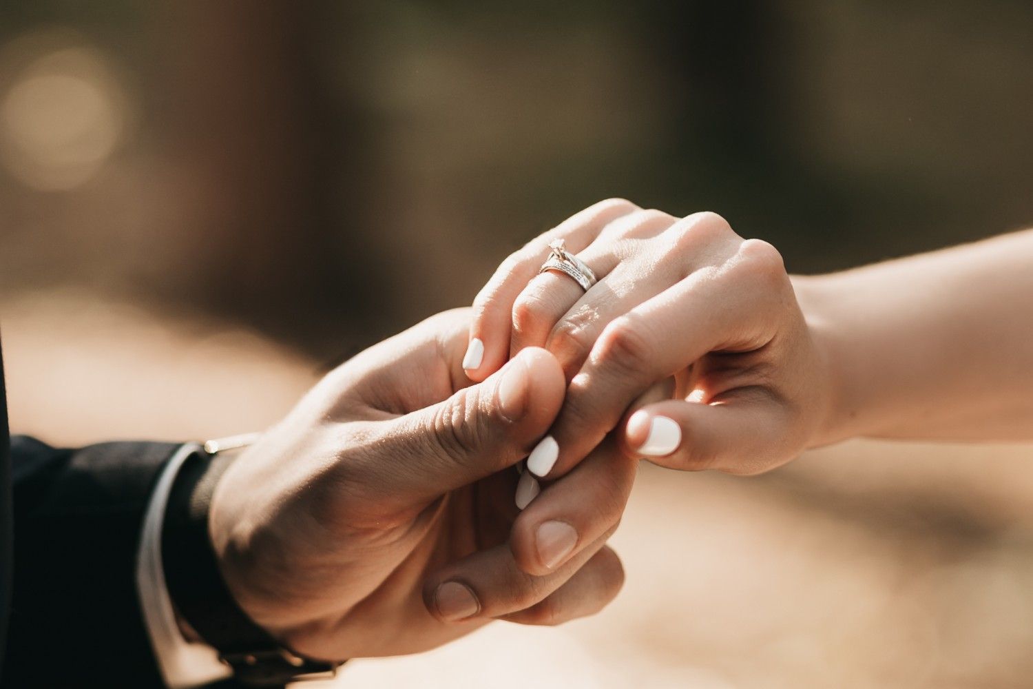 Couple holding hands with wedding ring – marriage-based visa and spousal green card process