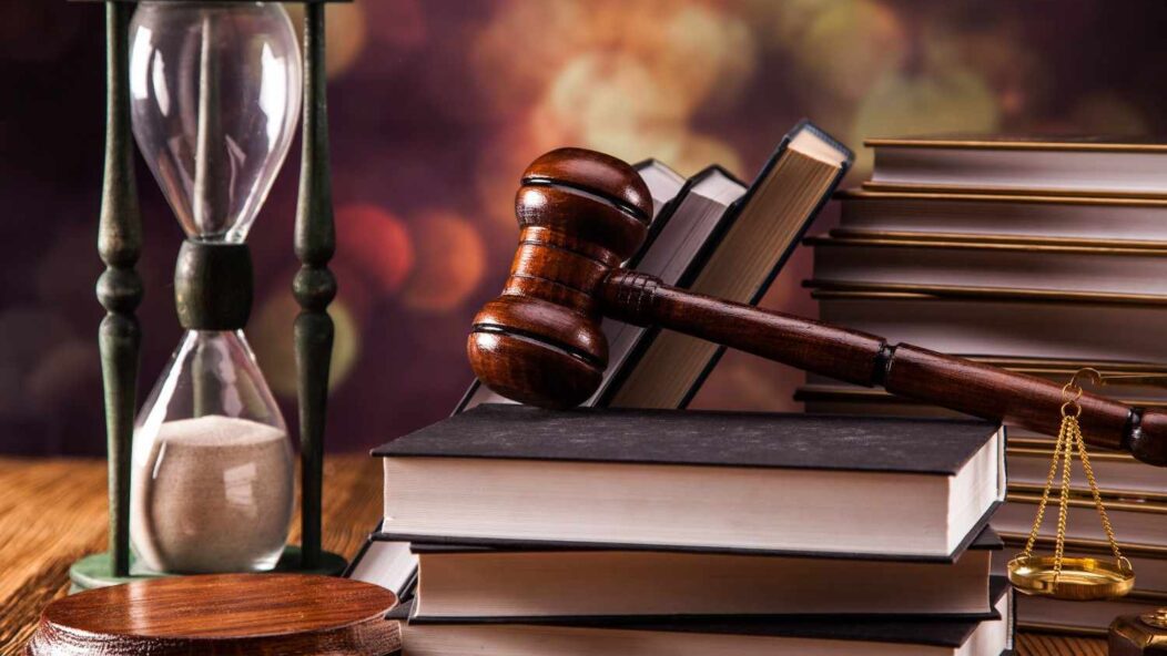 Judge gavel with law books and hourglass symbolizing mandamus lawsuit for delayed immigration application processing