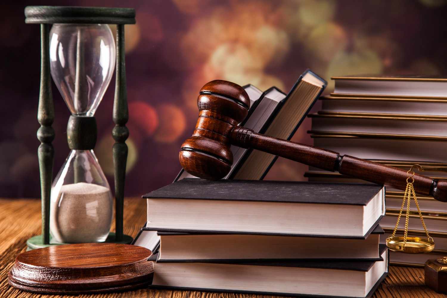 Judge gavel with law books and hourglass symbolizing mandamus lawsuit for delayed immigration application processing