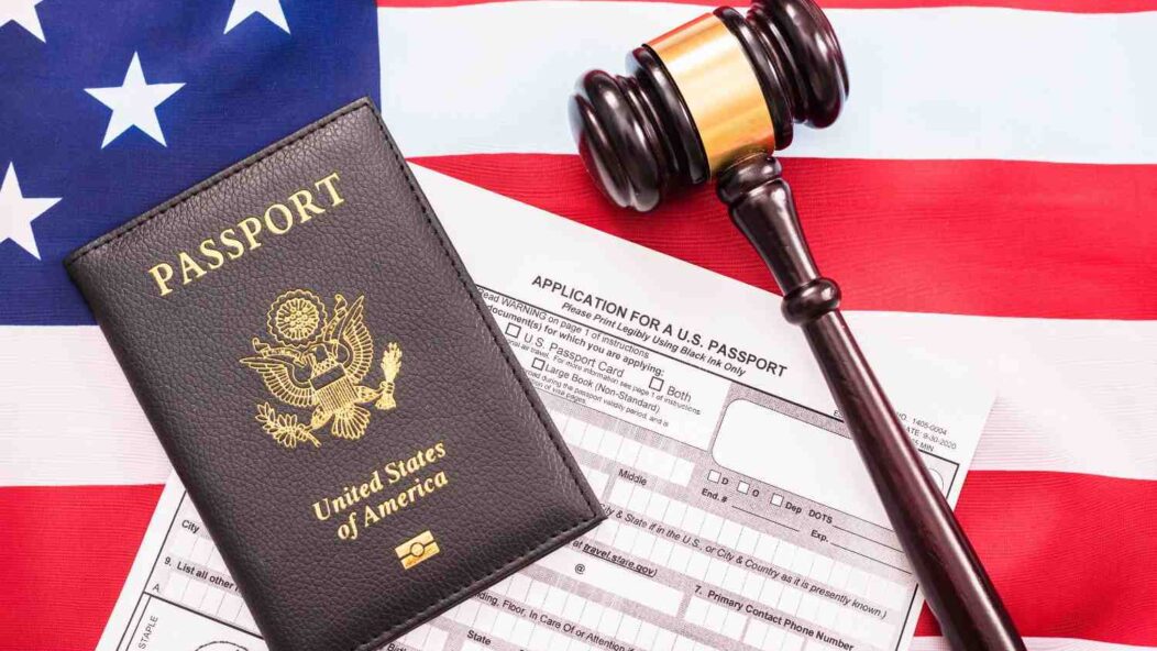 US passport with gavel on American flag symbolizing H-1B visa legal challenges and USCIS fraud by association revocations
