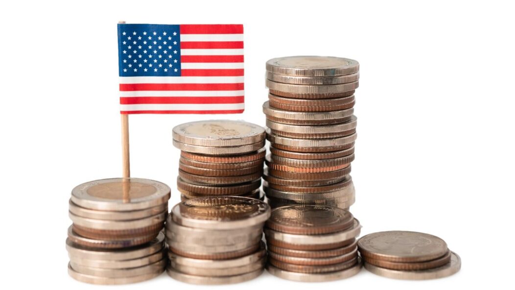 Stacked coins with U.S. flag representing USCIS self-funding model and immigration user fee costs