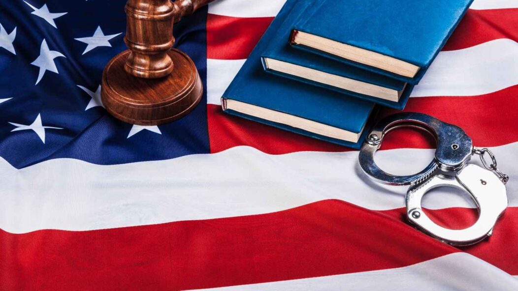 U.S. flag with gavel and handcuffs representing denaturalization and loss of U.S. citizenship due to fraud or crime