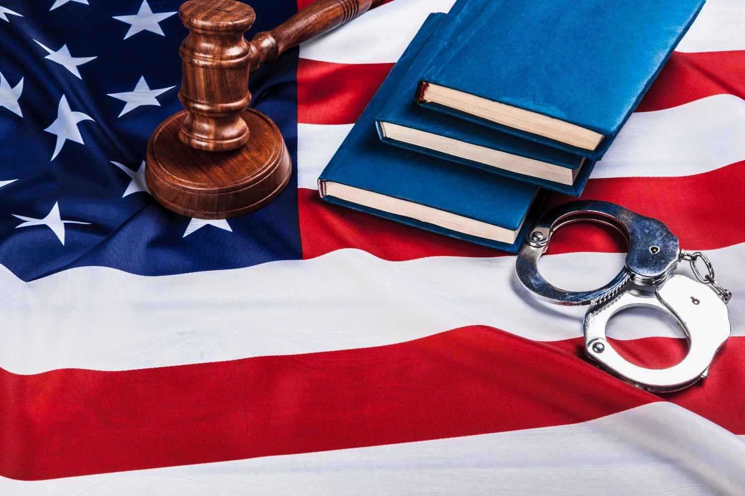 U.S. flag with gavel and handcuffs representing denaturalization and loss of U.S. citizenship due to fraud or crime