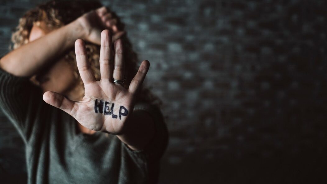 Domestic violence victim raising hand for help – immigrant protections and VAWA rights