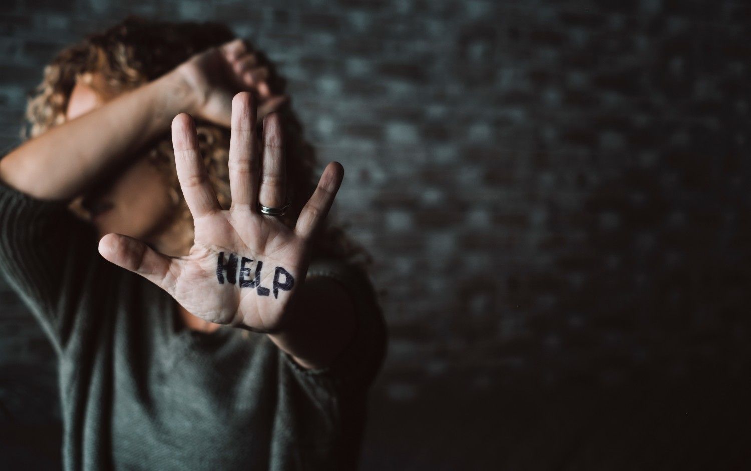 Domestic violence victim raising hand for help – immigrant protections and VAWA rights