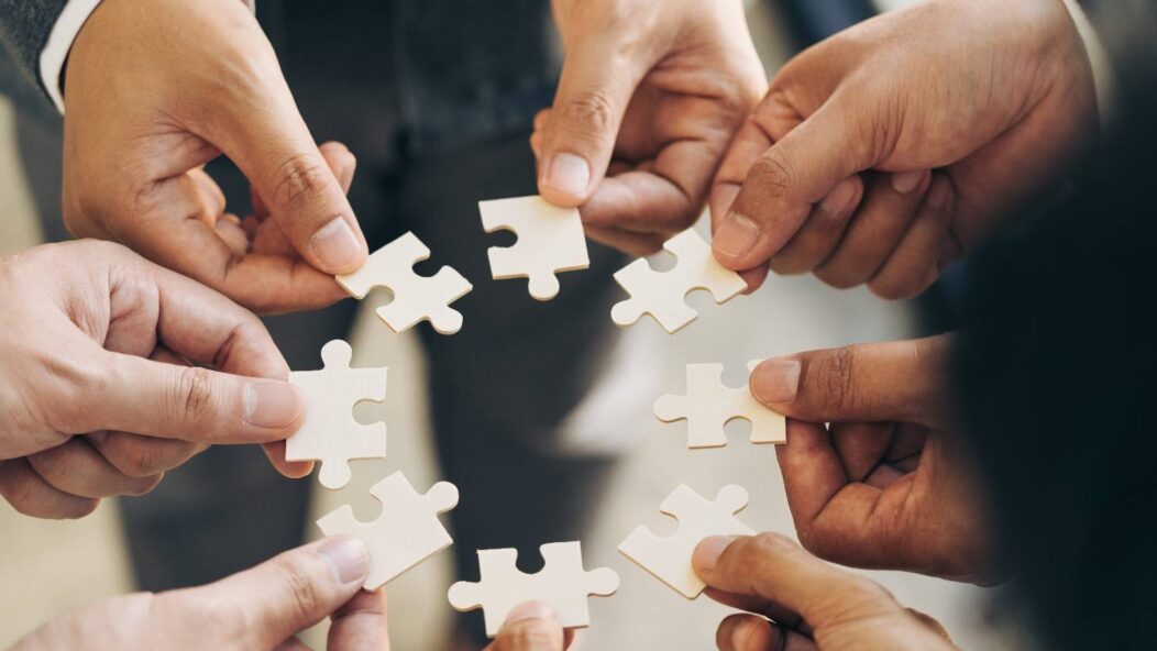 Hands connecting puzzle pieces representing Form I-140 petition filing process