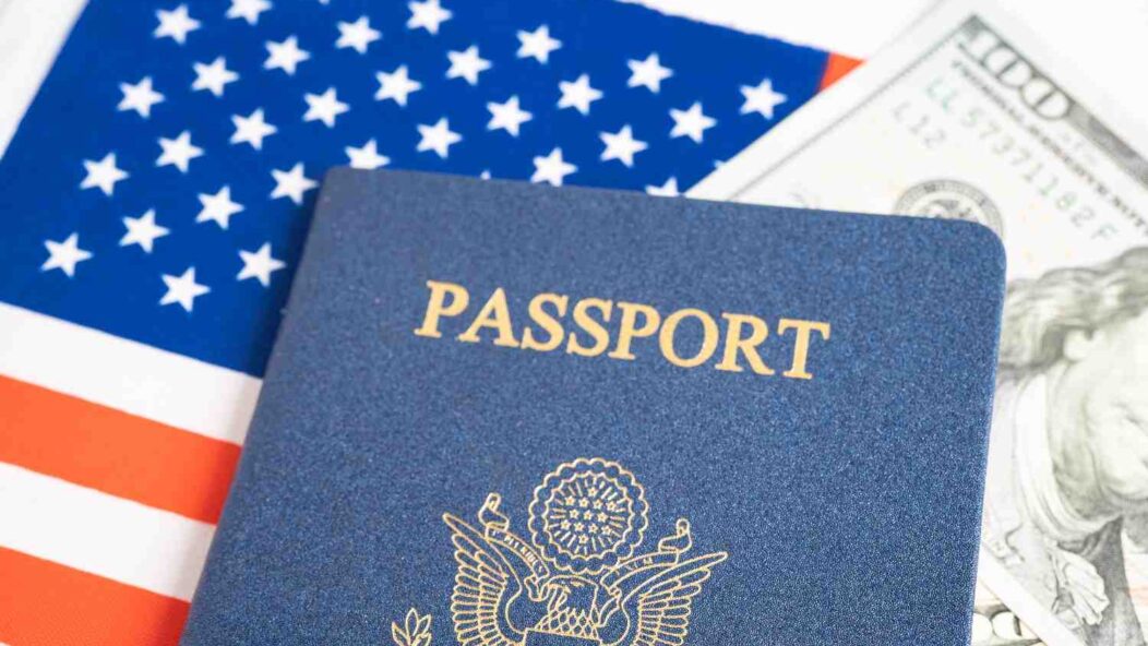 U.S. passport and dollar currency on American flag representing Green Card renewal process