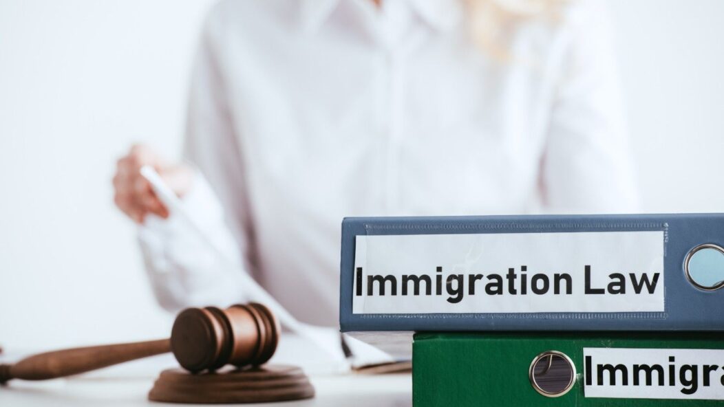Immigration law files and legal gavel representing U.S. immigration reforms under Public Law 100-525
