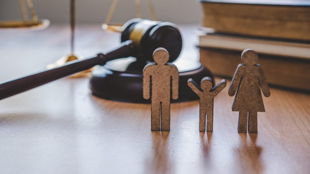 Family figures with judge gavel symbolizing Hague Convention international adoption law