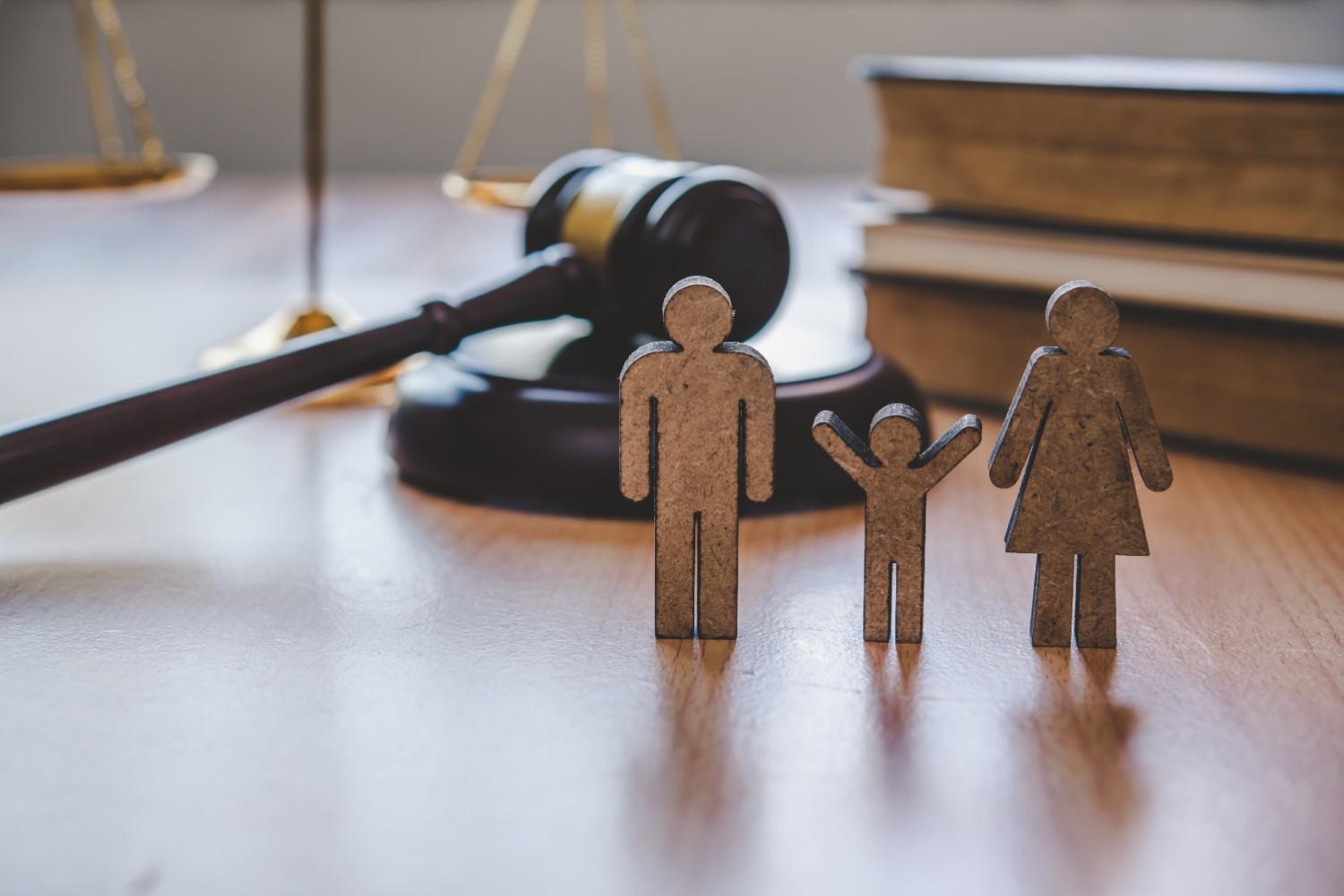 Family figures with judge gavel symbolizing Hague Convention international adoption law