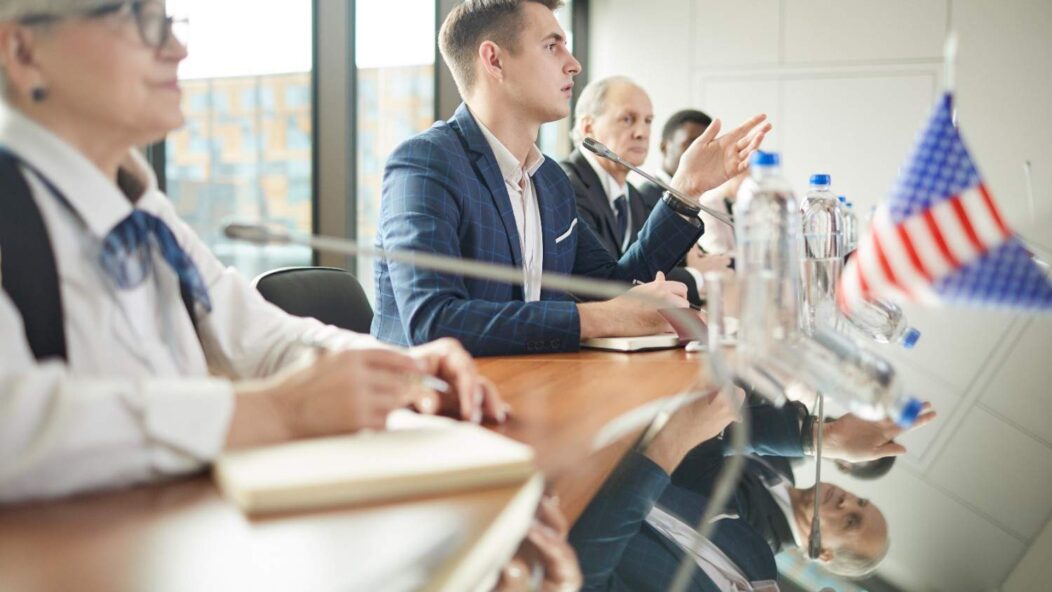 Immigrants taking the Oath of Allegiance during a naturalization ceremony in a large atrium, symbolizing the path to U.S. citizenship.