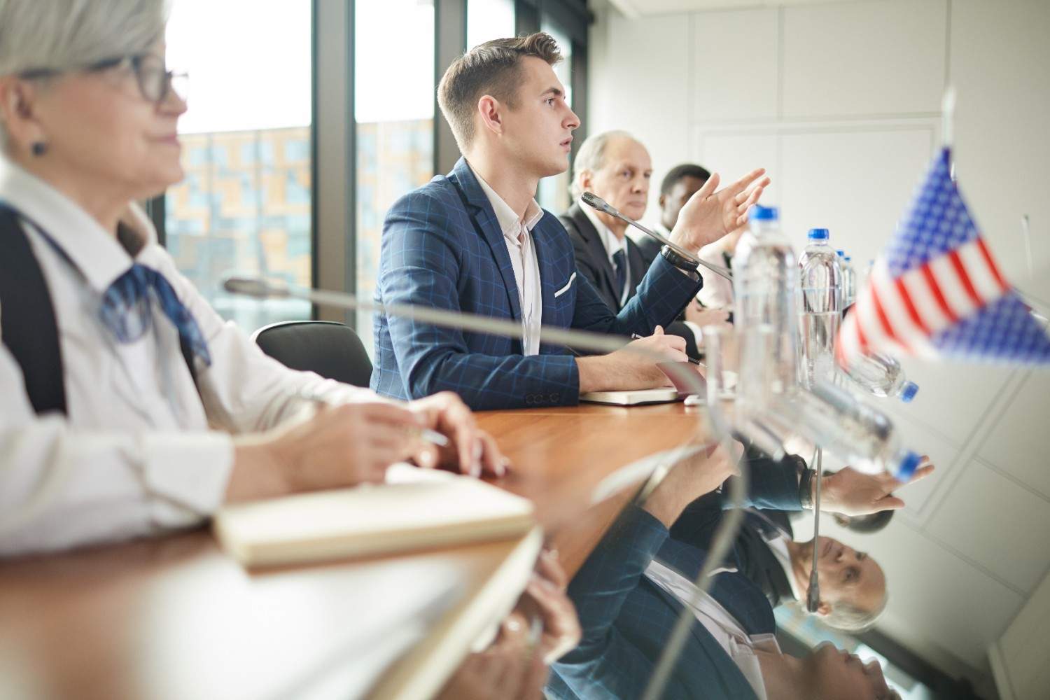 Immigrants taking the Oath of Allegiance during a naturalization ceremony in a large atrium, symbolizing the path to U.S. citizenship.
