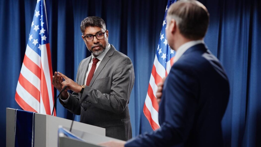 USCIS naturalization ceremony in Nevada, featuring attendees pledging allegiance with flags displayed, symbolizing U.S. citizenship process.