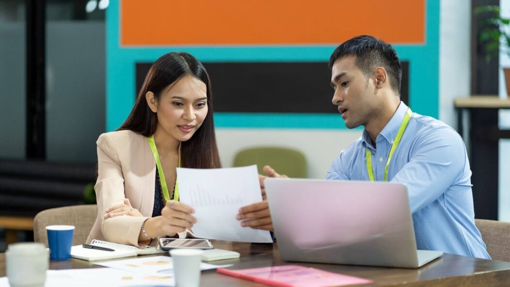 Two professionals discussing immigration documents, highlighting the impact of the December 2024 Visa Bulletin updates.