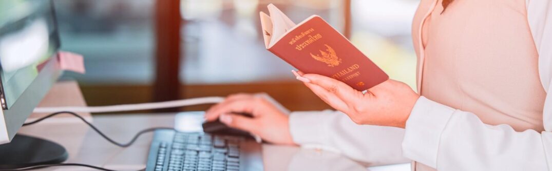 An immigration officer reviewing a passport and travel documents at an airport desk, highlighting the process of visa verification.