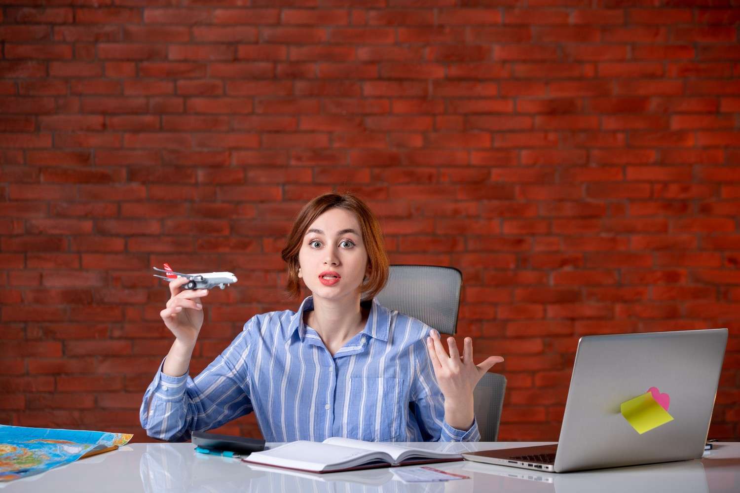 F-1 visa student holding a toy airplane, concerned about international travel limits under the 5-Month Rule, sitting at a desk with a map, laptop, and open notebook.