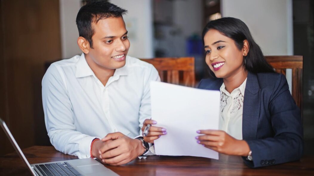 Two professionals discussing immigration documents, highlighting the impact of the December 2024 Visa Bulletin updates.