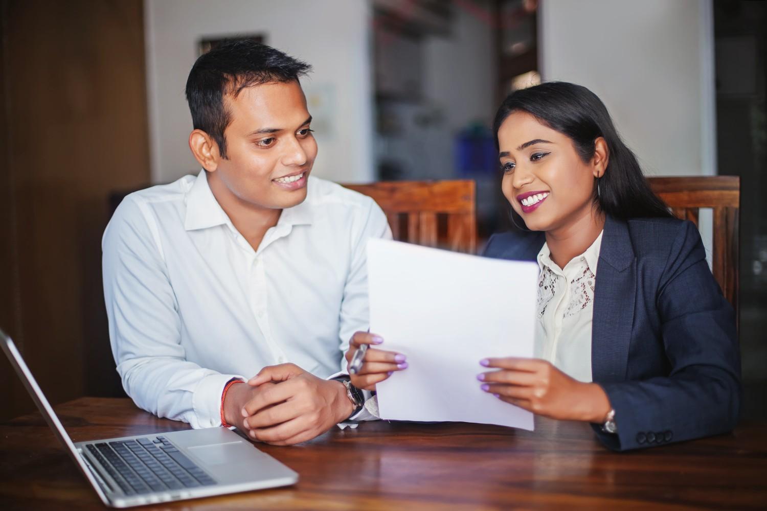 Two professionals discussing immigration documents, highlighting the impact of the December 2024 Visa Bulletin updates.