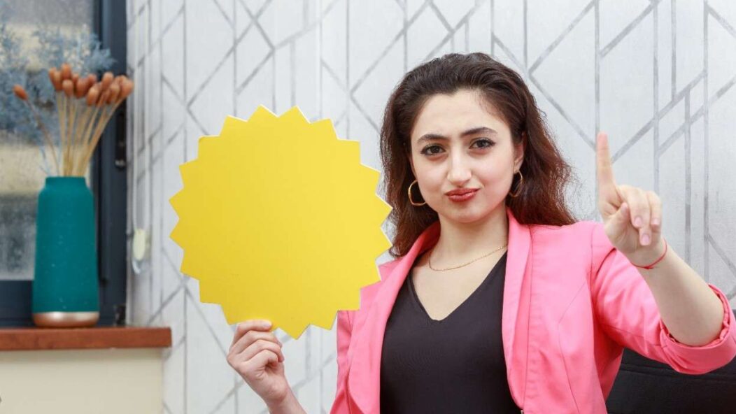 Professional woman holding a yellow star-shaped sign, emphasizing the 540-day EAD extension for seamless work authorization renewals.