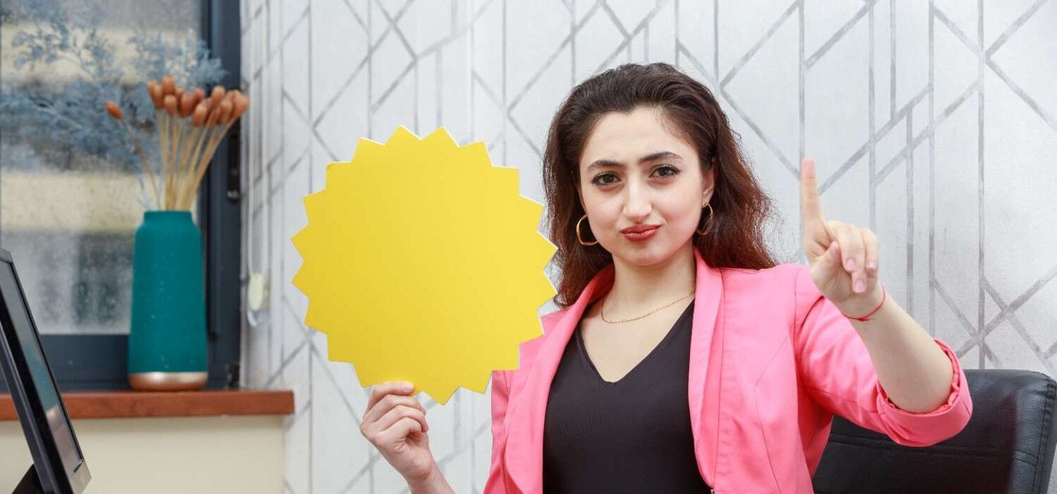 Professional woman holding a yellow star-shaped sign, emphasizing the 540-day EAD extension for seamless work authorization renewals.