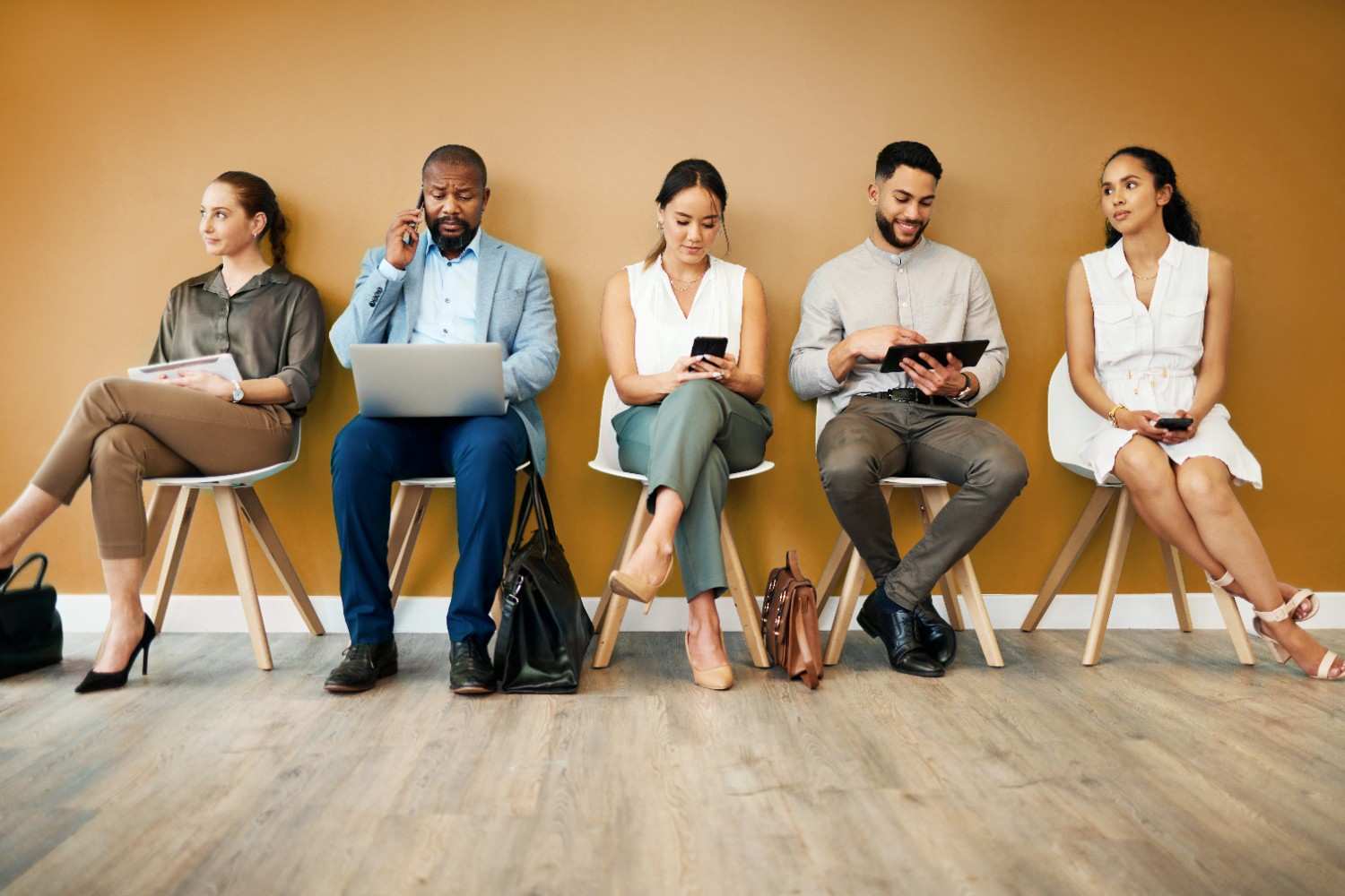 Professional workers in line for job opportunities with the words 'We Want You!' and a briefcase icon highlighting career recruitment.