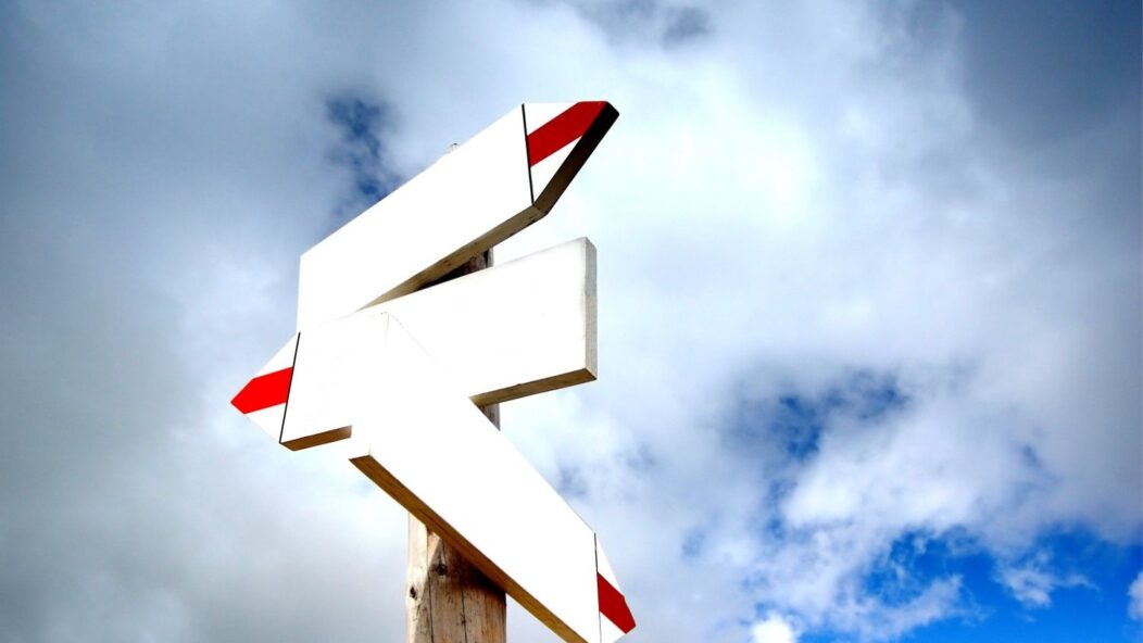 Signpost symbolizing changes in direction under a clear sky, representing the CBP One app impact on border entry processes.