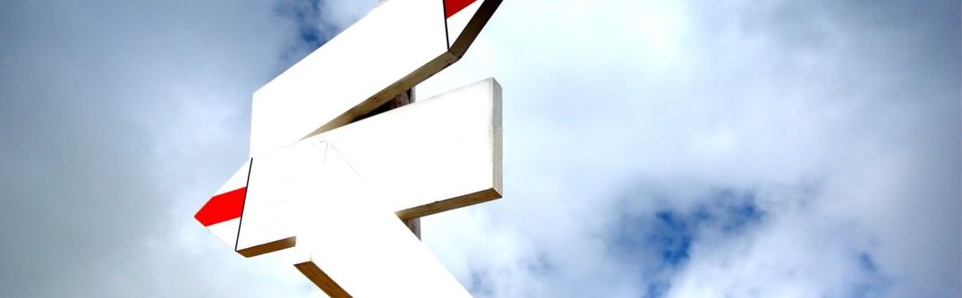 Signpost symbolizing changes in direction under a clear sky, representing the CBP One app impact on border entry processes.