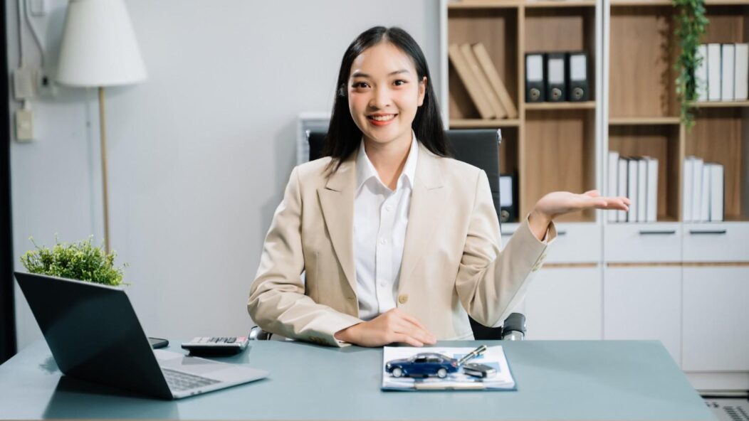 Confused professional woman sitting at a desk with documents, illustrating changes in USCIS rules for immigration fees.