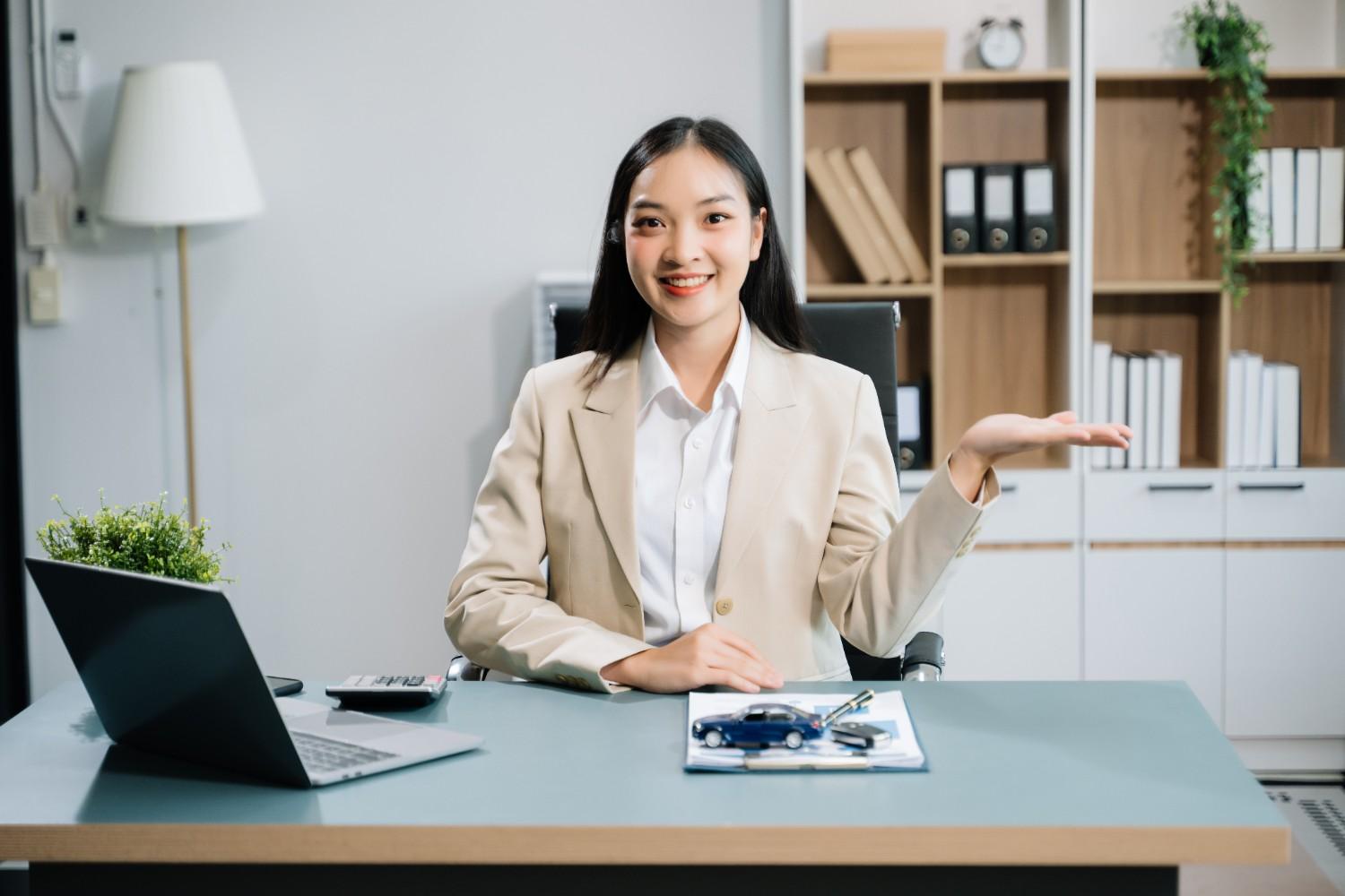 Confused professional woman sitting at a desk with documents, illustrating changes in USCIS rules for immigration fees.
