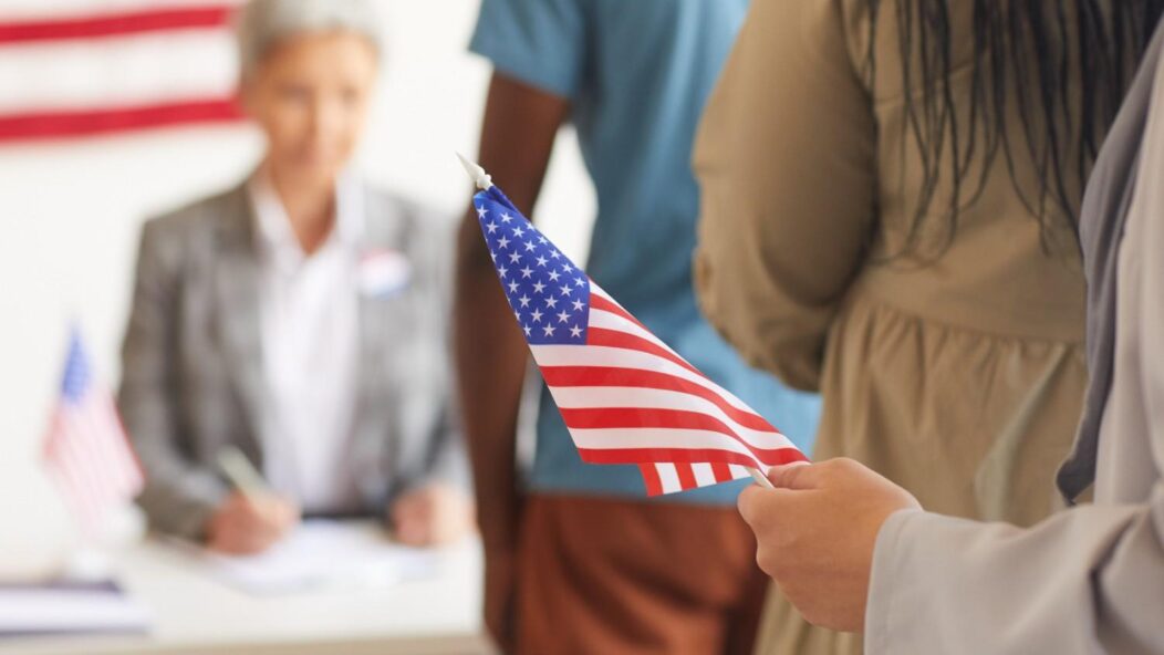 Three diverse individuals discussing a document, symbolizing inclusivity and accessibility in the naturalization process.