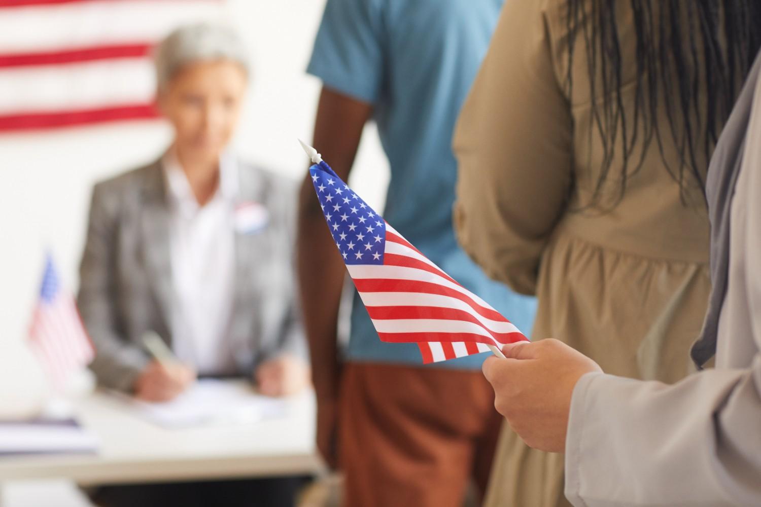 Three diverse individuals discussing a document, symbolizing inclusivity and accessibility in the naturalization process.