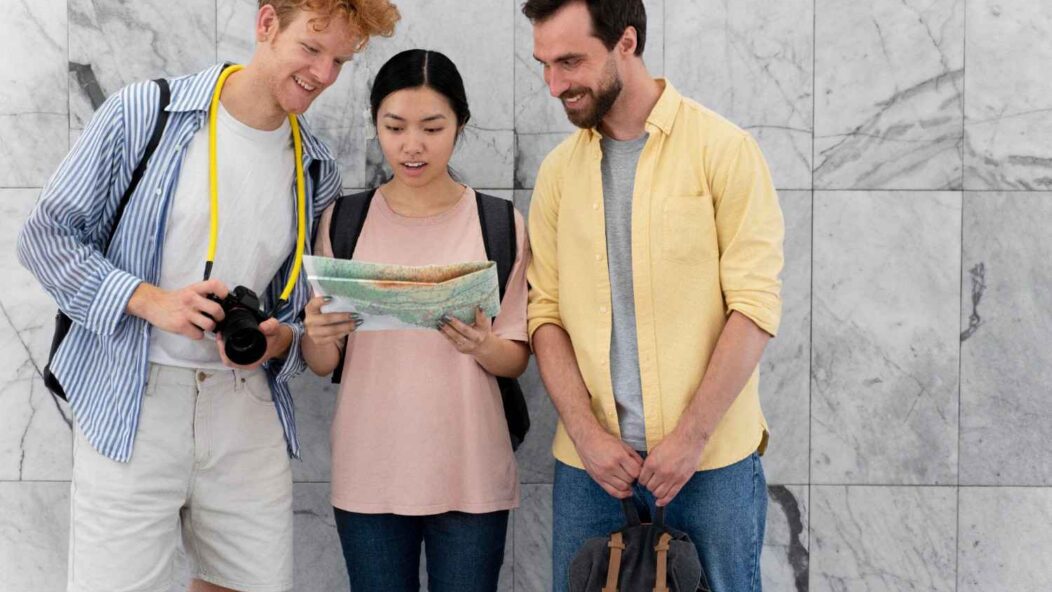 Three diverse individuals discussing a document, symbolizing inclusivity and accessibility in the naturalization process.