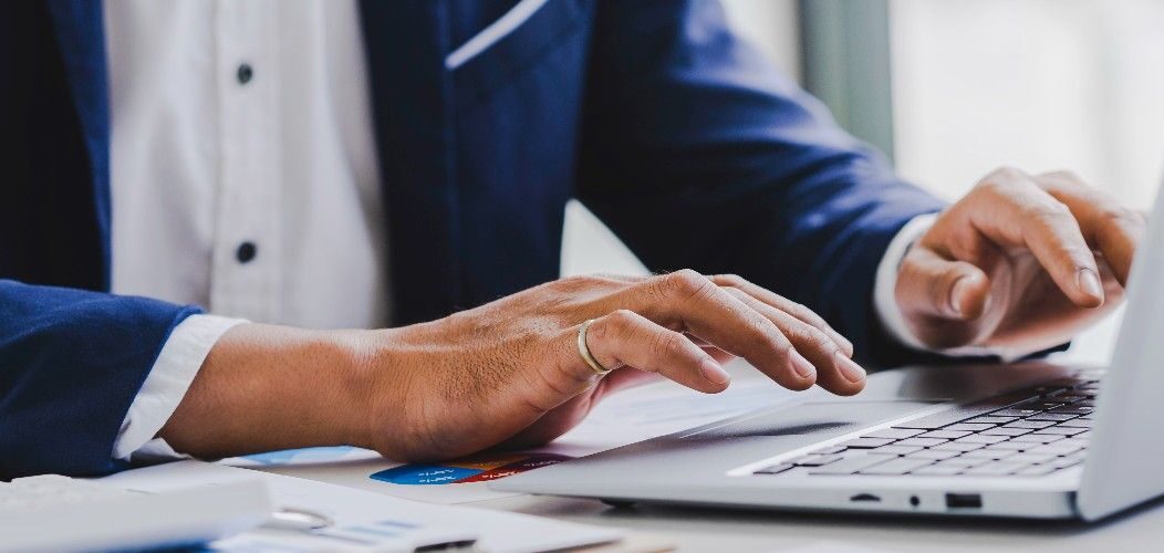 Business professional registering for FY 2026 H-1B visa process on computer, with registration form visible