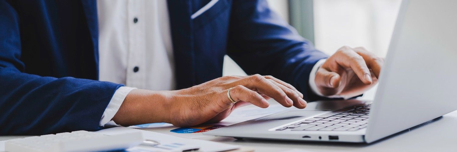 Business professional registering for FY 2026 H-1B visa process on computer, with registration form visible