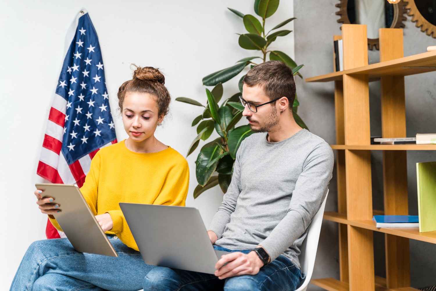 International students discussing F1 visa entry requirements with the U.S. flag in the background, ensuring smooth immigration processing.