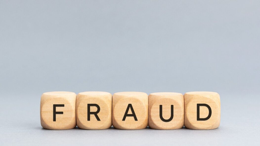 Magnifying glass focusing on the word 'FRAUD' representing H1B visa fraud litigation and revocation issues