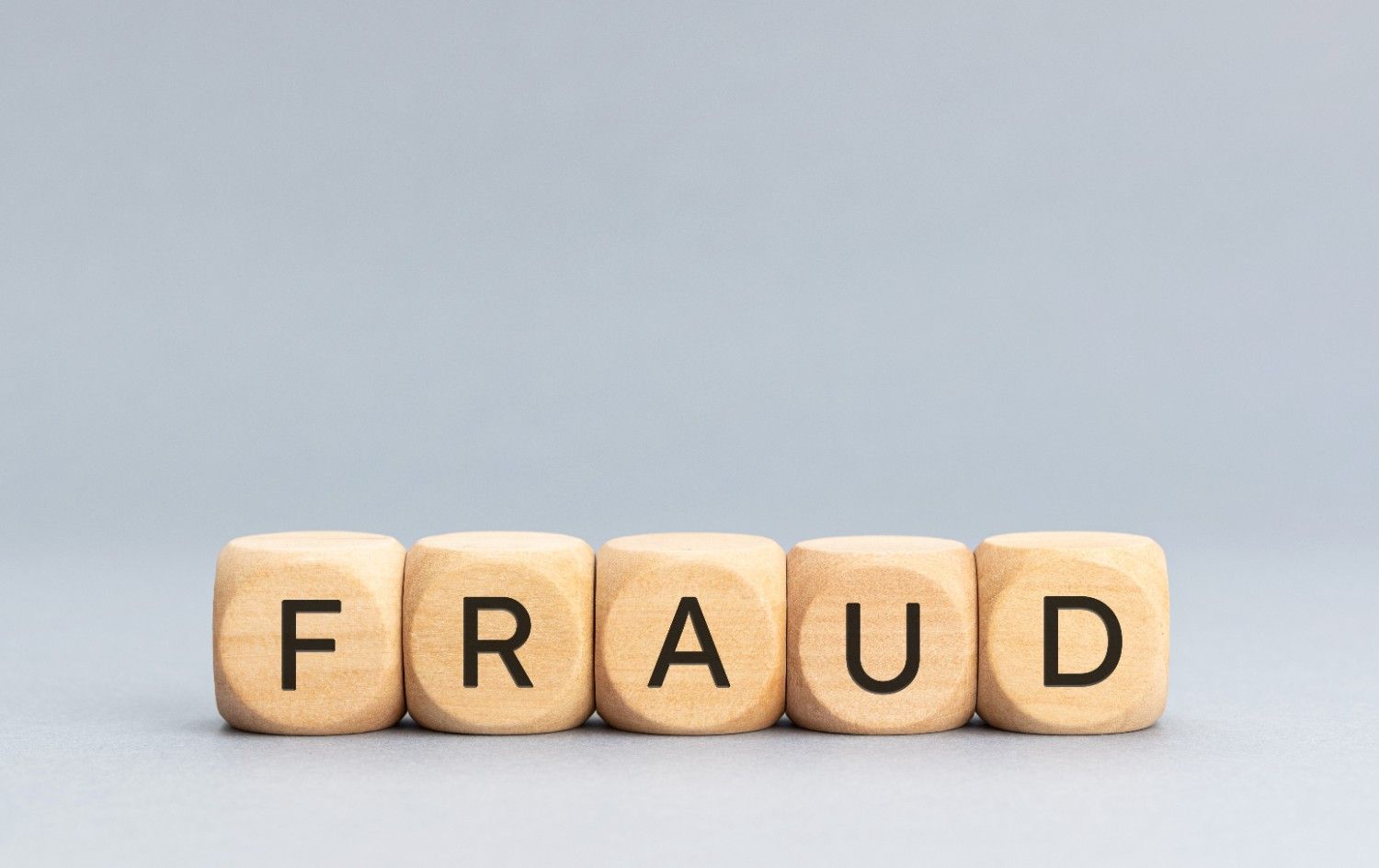 Magnifying glass focusing on the word 'FRAUD' representing H1B visa fraud litigation and revocation issues