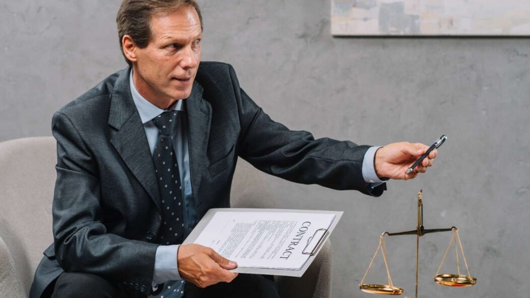 Immigration attorney discussing H-1B visa revocation legal remedies with a client, holding a contract and pen, symbolizing legal counsel and professional guidance.