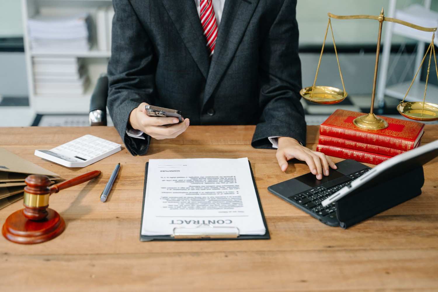 Immigration attorney discussing H-1B visa revocation legal remedies with a client, holding a contract and pen, symbolizing legal counsel and professional guidance.