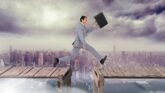 Businessman jumping across a broken bridge over a city skyline, symbolizing overcoming L-1A visa denial challenges and navigating the appeal process.