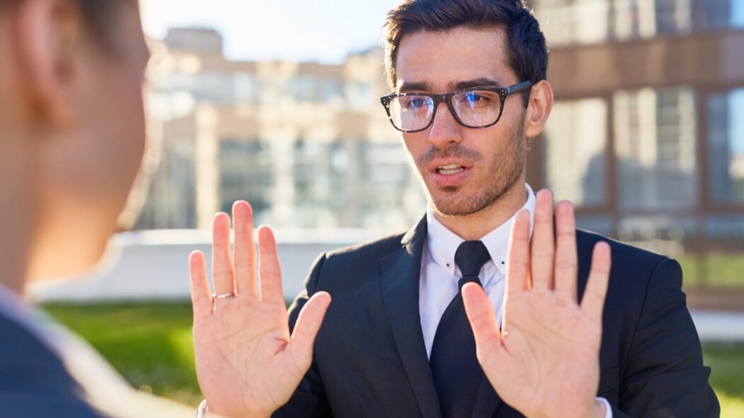 Man explaining response to USCIS NOID with hands raised, discussing immigration concerns.