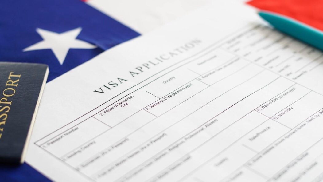 US visa stamping process with approved application form, passport, and American flag