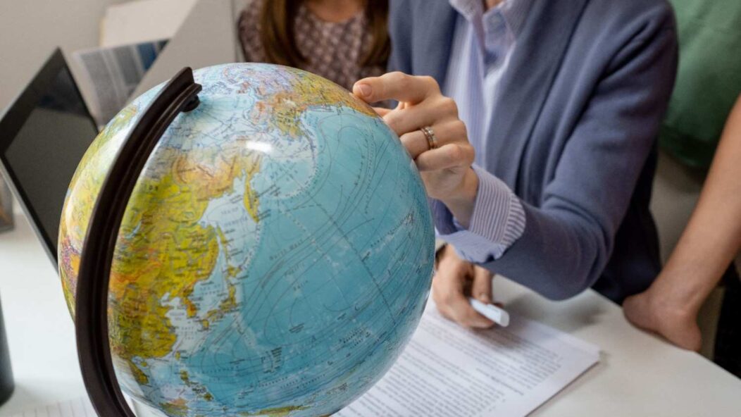 Immigration attorney discussing 221(g) visa notice and administrative processing with a client, showing the globe and documents.