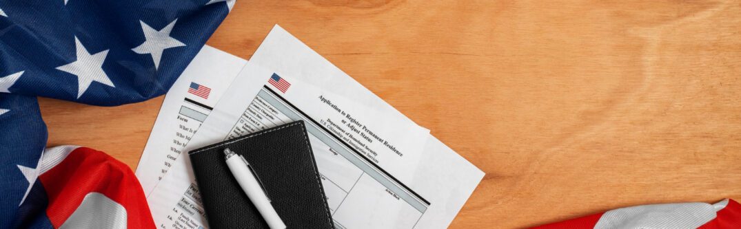 U.S. passport, green card, and Statue of Liberty souvenir on American flag - Immigration and Visa Process.
