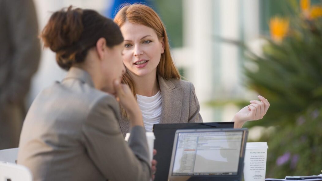 Immigration attorney services - two professionals collaborating on legal documents outdoors.