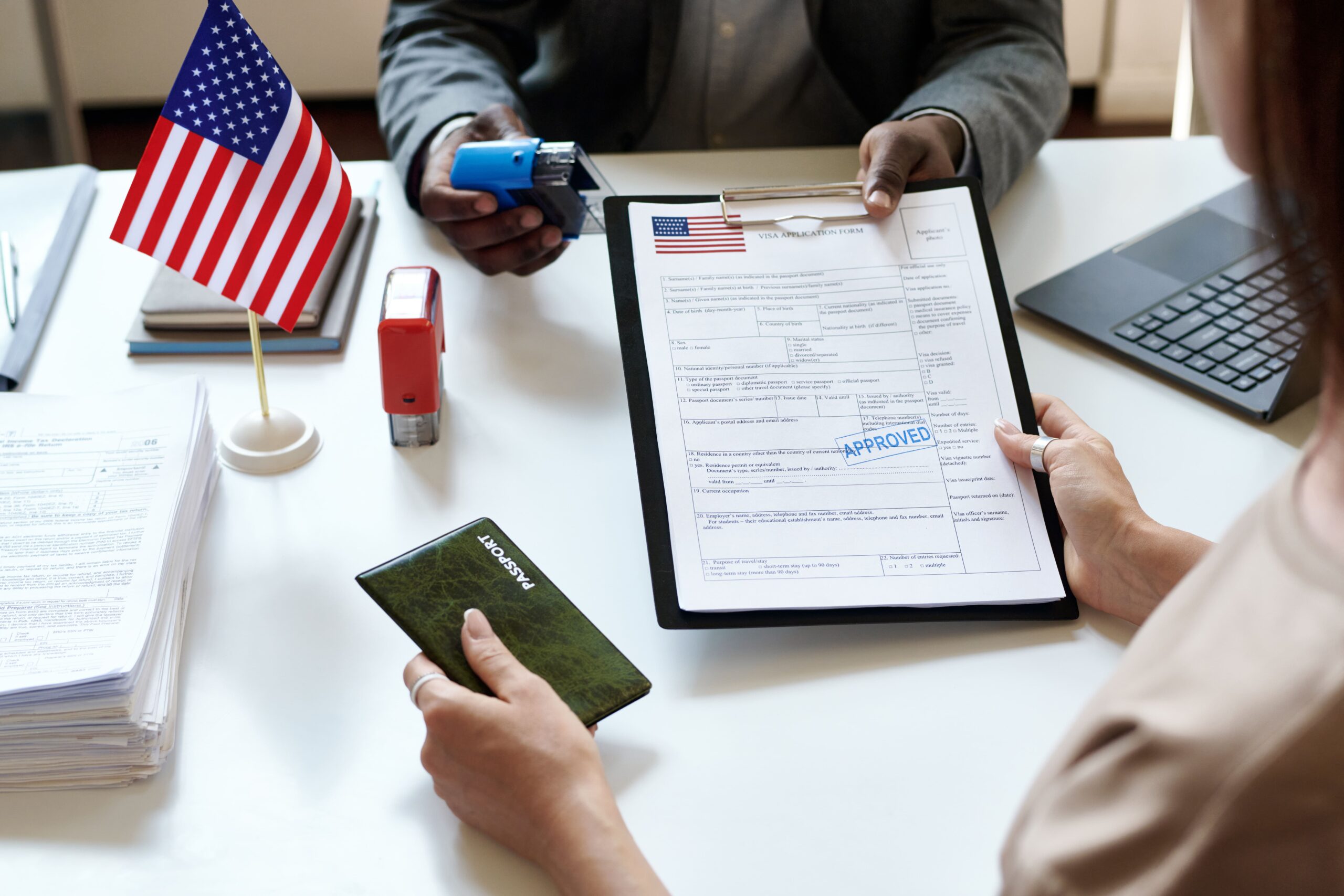 Student with laptop surrounded by social media icons and a U.S. visa application, representing the impact of social media on U.S. student visas.