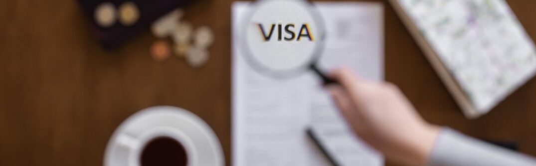 Magnifying glass highlighting the word VISA on legal documents – Visa Revocation Legal Help
