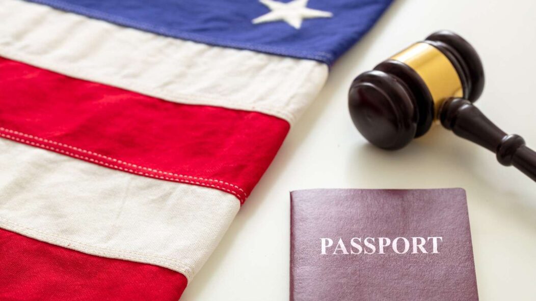 American flag, judge's gavel, and passport representing U.S. immigration law and petition revocation