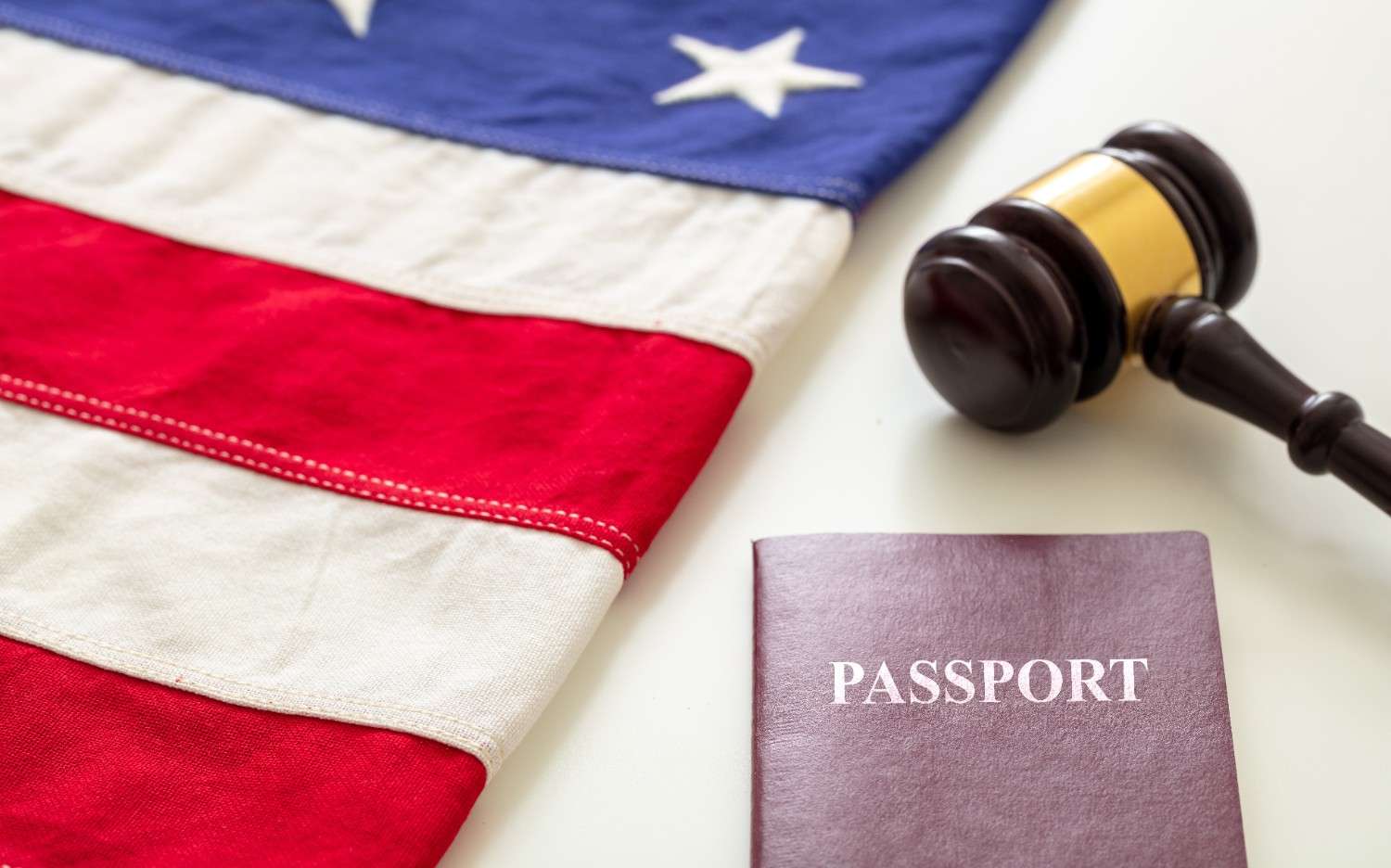 American flag, judge's gavel, and passport representing U.S. immigration law and petition revocation